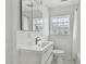 Clean bathroom featuring a modern vanity, toilet, and glass block window at 7224 Park S St, St Pete Beach, FL 33707