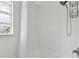 Close-up of a clean, tiled shower and bathtub with a glass block window in a bathroom at 7224 Park S St, St Pete Beach, FL 33707