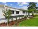 Charming home detail featuring a garden with lush greenery, flowering plants, and a beautifully maintained lawn at 7224 Park S St, St Pete Beach, FL 33707