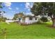 Beautiful white single-story house with green grass, surrounded by lush greenery and well-kept landscaping at 7224 Park S St, St Pete Beach, FL 33707