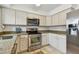 An open kitchen with stainless steel appliances, granite countertops, and white cabinets at 7224 Park S St, St Pete Beach, FL 33707