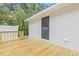 Backyard exterior featuring a wooden deck attached to a white house with gray door at 731 38Th N Ave, St Petersburg, FL 33704