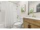 Bright bathroom with a shower and bathtub, white tiling, and a wooden vanity with gold hardware at 731 38Th N Ave, St Petersburg, FL 33704