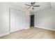 Bedroom with light wood flooring, ceiling fan, closet with white paneled doors, and gray walls at 731 38Th N Ave, St Petersburg, FL 33704