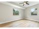 Empty bedroom with wood floors, a ceiling fan, and lots of natural light from two windows at 731 38Th N Ave, St Petersburg, FL 33704