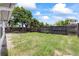 Spacious backyard featuring a wooden fence, mature trees, and ample space for outdoor activities at 7330 Abalone Dr, Port Richey, FL 34668