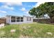 Home's backyard has grass and trees with partial privacy fence in the background at 7330 Abalone Dr, Port Richey, FL 34668