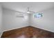 Cozy bedroom featuring hardwood floors, neutral wall paint, and plenty of natural light at 7330 Abalone Dr, Port Richey, FL 34668