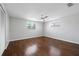 The bedroom features hardwood floors, a ceiling fan, and large bright windows at 7330 Abalone Dr, Port Richey, FL 34668
