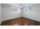 Bedroom with hardwood flooring and two windows providing natural light at 7330 Abalone Dr, Port Richey, FL 34668