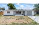 Charming single-story home with a gray roof, front yard, and a one-car garage at 7330 Abalone Dr, Port Richey, FL 34668