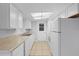 Functional kitchen featuring white appliances, plenty of counter space, and tile flooring at 7330 Abalone Dr, Port Richey, FL 34668