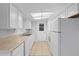 Bright kitchen with white cabinets, neutral countertops, and tile flooring at 7330 Abalone Dr, Port Richey, FL 34668