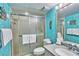 Light and bright bathroom with turquoise walls, a walk-in shower, and plenty of space is ready for your personal touch at 7564 Bayshore Dr # 202, Treasure Island, FL 33706