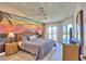 Spacious main bedroom with a beautiful mural, ceiling fan, and a private balcony with stunning views awaits at 7564 Bayshore Dr # 202, Treasure Island, FL 33706