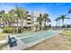 Enjoy a game of shuffleboard at the community courts near the building and lush landscaping at 7564 Bayshore Dr # 202, Treasure Island, FL 33706
