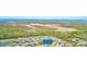 Scenic aerial view showcases neighborhood with pond, trees, and glimpse of the ocean in the background at 7823 Hardwick Dr # 224, New Port Richey, FL 34653