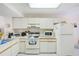 Bright kitchen with white cabinetry, appliances, and tile flooring at 7823 Hardwick Dr # 224, New Port Richey, FL 34653
