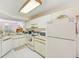 Bright kitchen with white cabinetry, appliances, and tile flooring at 7823 Hardwick Dr # 224, New Port Richey, FL 34653