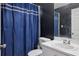 A bathroom features a blue shower curtain and a single sink vanity at 814 Cape Cod Cir, Valrico, FL 33594