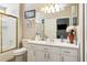 Bright bathroom featuring a single sink vanity, a full mirror, and a shower with gold trim at 814 Cape Cod Cir, Valrico, FL 33594