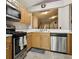 Efficient kitchen layout with stainless steel appliances and warm wood cabinetry with a connecting view to living space at 814 Cape Cod Cir, Valrico, FL 33594