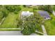 Aerial view of single-story home with large tree in yard on a tree-lined street at 8329 Gulf Way, Hudson, FL 34667