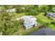 Aerial view of single-story home with landscaping, backyard, and damaged roof in a wooded area at 8329 Gulf Way, Hudson, FL 34667