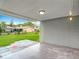 Covered back patio with a view of the expansive backyard and neighboring properties at 8329 Gulf Way, Hudson, FL 34667