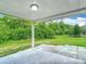 Covered back patio area that is perfect for outdoor seating with a large backyard and green lush foliage at 8329 Gulf Way, Hudson, FL 34667