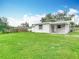 Large backyard with a well-maintained lawn and a covered patio area, ideal for relaxation and recreation at 8329 Gulf Way, Hudson, FL 34667