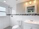 Bathroom with white tiled shower, mosaic accents, modern lighting, and vanity with sink at 8329 Gulf Way, Hudson, FL 34667