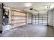 View of spacious garage with open shelving and garage door at 8329 Gulf Way, Hudson, FL 34667
