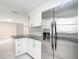 Bright kitchen features granite countertops, white cabinets, stainless steel refrigerator, and modern finishes at 8329 Gulf Way, Hudson, FL 34667