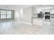 Spacious living room showcasing open floor plan with kitchen, new flooring, and neutral colors at 8329 Gulf Way, Hudson, FL 34667