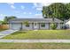 Charming single-story home featuring a well-manicured lawn, decorative ironwork, and a welcoming front entrance at 9053 Hickory Cir, Tampa, FL 33615