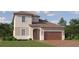 Charming two-story home showcasing a well-manicured lawn and a welcoming, arched entryway at 9779 Minnow Ray Dr, Land O Lakes, FL 34638