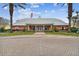 The community clubhouse with an American flag, green lawn, palm trees, and a brick drive at 101 Pompano Se Dr # C, St Petersburg, FL 33705