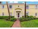 Charming condominium entrance featuring yellow walls and manicured landscaping along the brick path at 101 Pompano Se Dr # C, St Petersburg, FL 33705