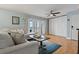 Open living room area with a comfortable sofa, wood flooring, and french doors to the balcony view at 101 Pompano Se Dr # C, St Petersburg, FL 33705