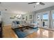 Cozy living room featuring a plush sofa, stylish lighting, and access to a balcony with water views at 101 Pompano Se Dr # C, St Petersburg, FL 33705