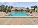 A large community pool with a clubhouse in the background is surrounded by lounge chairs at 101 Pompano Se Dr # C, St Petersburg, FL 33705