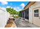 Backyard patio features a screened in porch, accessible by a door and surrounded by lush greenery and plants at 10407 Oleander Dr, Port Richey, FL 34668