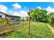 Landscaped backyard bordering a canal, featuring a wooden bird house and secure fencing at 10407 Oleander Dr, Port Richey, FL 34668