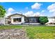 Exterior view of the home, revealing an expansive backyard with a well-manicured lawn and tropical landscaping at 10407 Oleander Dr, Port Richey, FL 34668