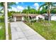 Charming home with a well-maintained lawn, long driveway, and a convenient one-car garage at 10407 Oleander Dr, Port Richey, FL 34668