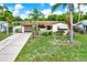 Inviting single-story home with a manicured lawn, mature palm trees, and a driveway at 10407 Oleander Dr, Port Richey, FL 34668