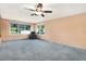 Spacious sunroom with a large ceiling fan, lots of light and plush carpeting at 10407 Oleander Dr, Port Richey, FL 34668