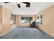 Bright sunroom featuring a comfortable armchair, carpet, and ample natural light at 10407 Oleander Dr, Port Richey, FL 34668