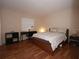 A simple bedroom with laminate flooring, neutral paint, and a desk setup for working at home at 120 S Church Ave # 202, Tampa, FL 33609
